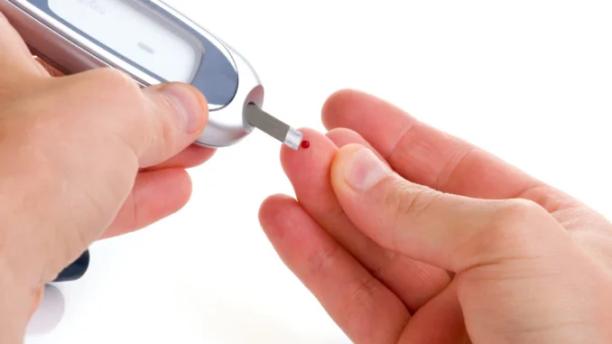 Diabetic is doing a glucose level finger blood test.